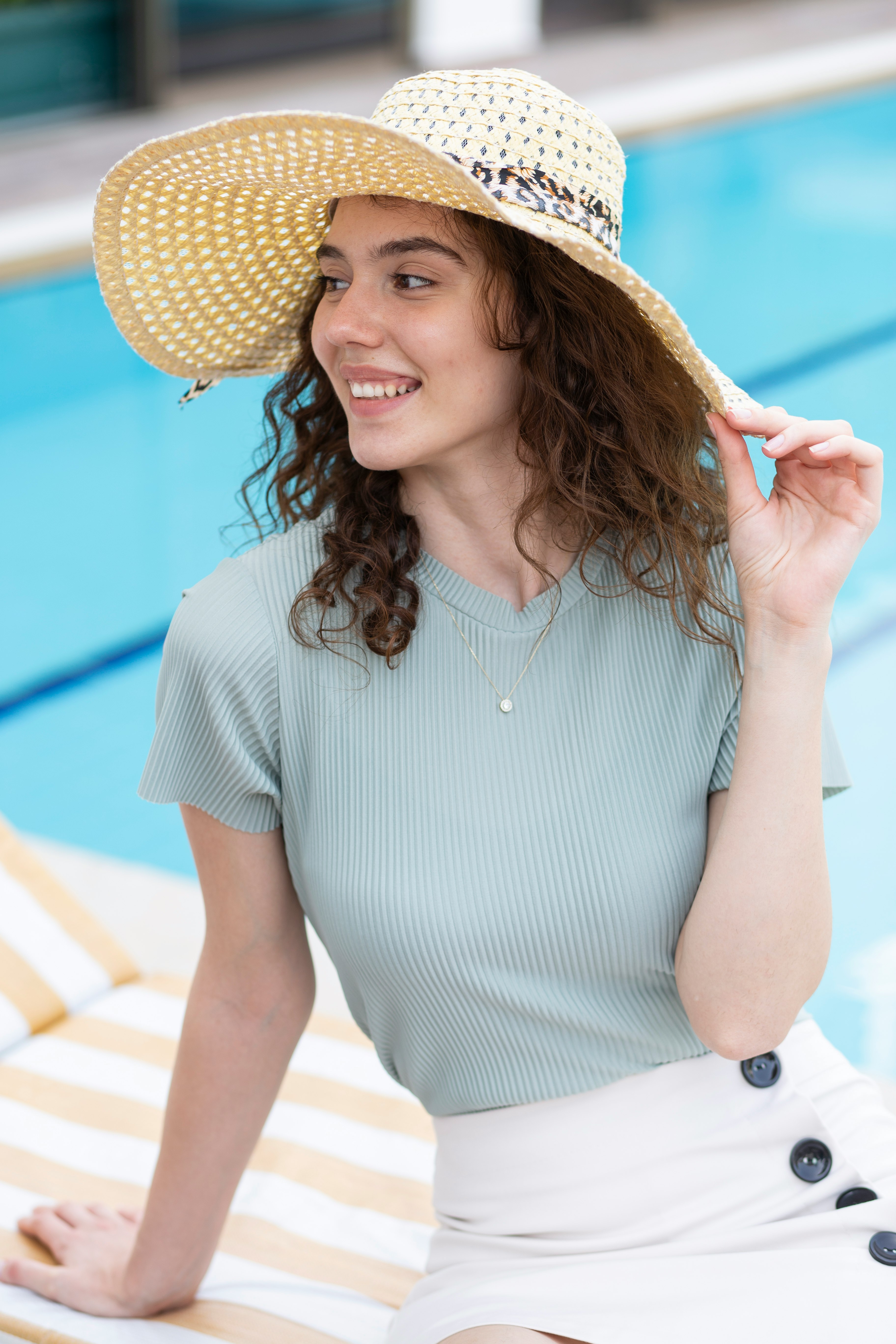 woman in white and blue striped dress wearing brown straw hat